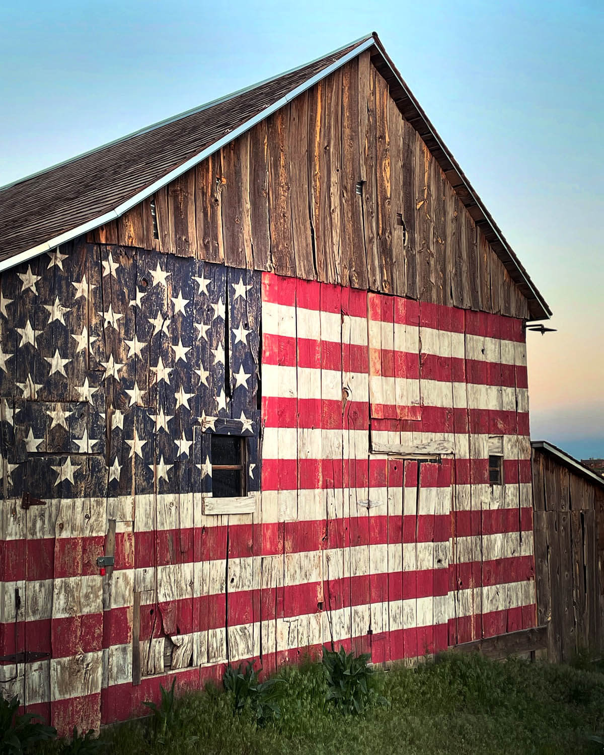 American flag painted on the side of a rustic barn